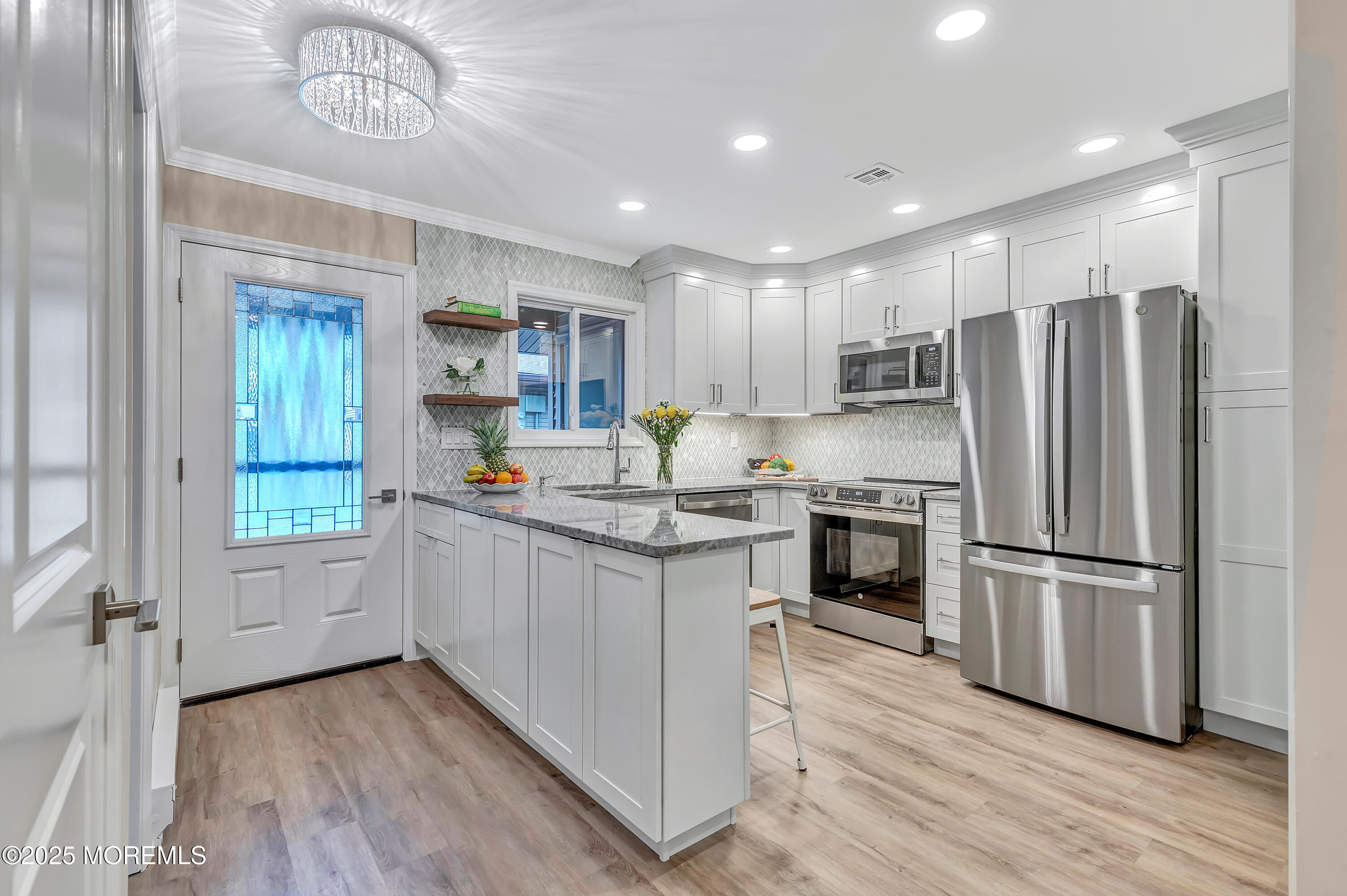 10 Ellsworth Court Red Bank, NJ 07701 - Photo 7 of 40 a kitchen with kitchen island granite countertop a refrigerator oven a sink dishwasher and white cabinets with wooden floor