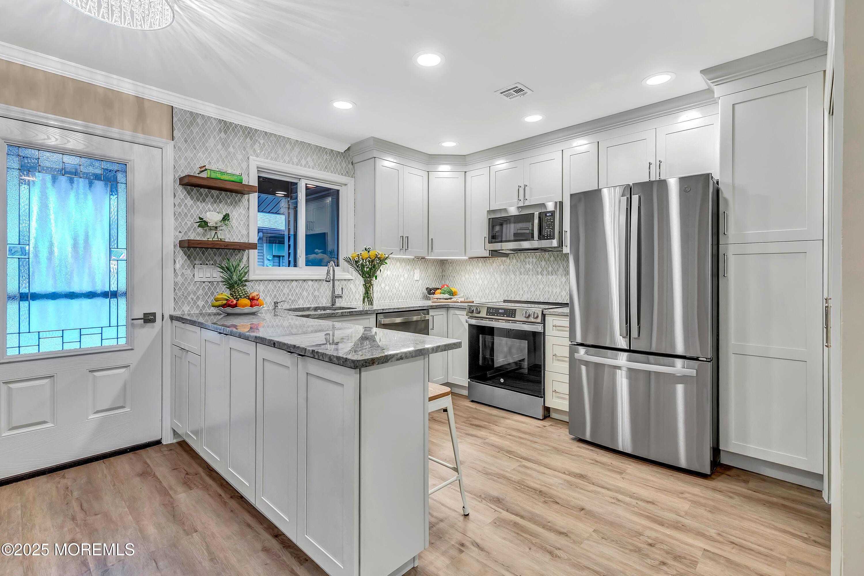 10 Ellsworth Court Red Bank, NJ 07701 - Photo 8 of 40 a kitchen with stainless steel appliances granite countertop a refrigerator a sink dishwasher a stove and white countertops with wooden floor