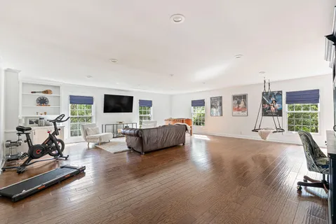 a living room with furniture flat screen tv and a large window
