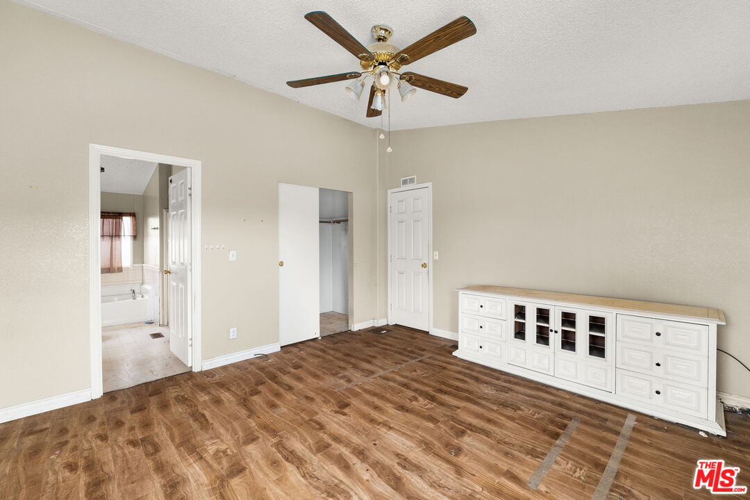 6425 Smoke Tree Road Phelan, CA 92371 - Photo 11 of 35 a bedroom with a large bed and a chandelier