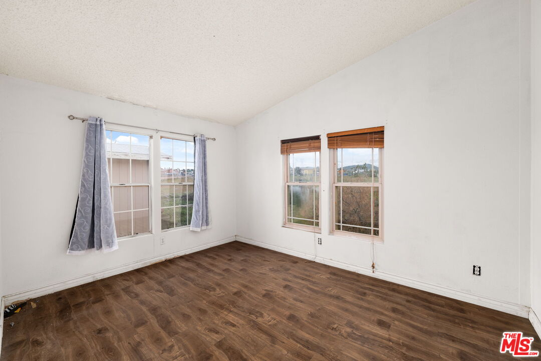 6425 Smoke Tree Road Phelan, CA 92371 - Photo 14 of 35 an empty room with wooden floor and windows