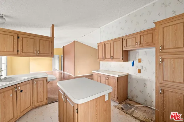 a kitchen with a sink a stove a refrigerator and cabinets