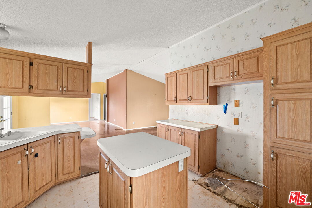 6425 Smoke Tree Road Phelan, CA 92371 - Photo 10 of 35 a kitchen with a sink a stove a refrigerator and cabinets