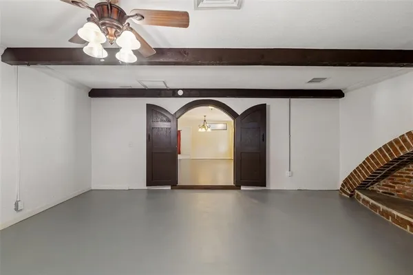 an empty room with a ceiling fan and a large window