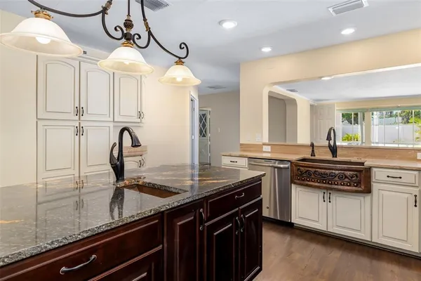 a kitchen with stainless steel appliances granite countertop a stove top oven a sink and a refrigerator
