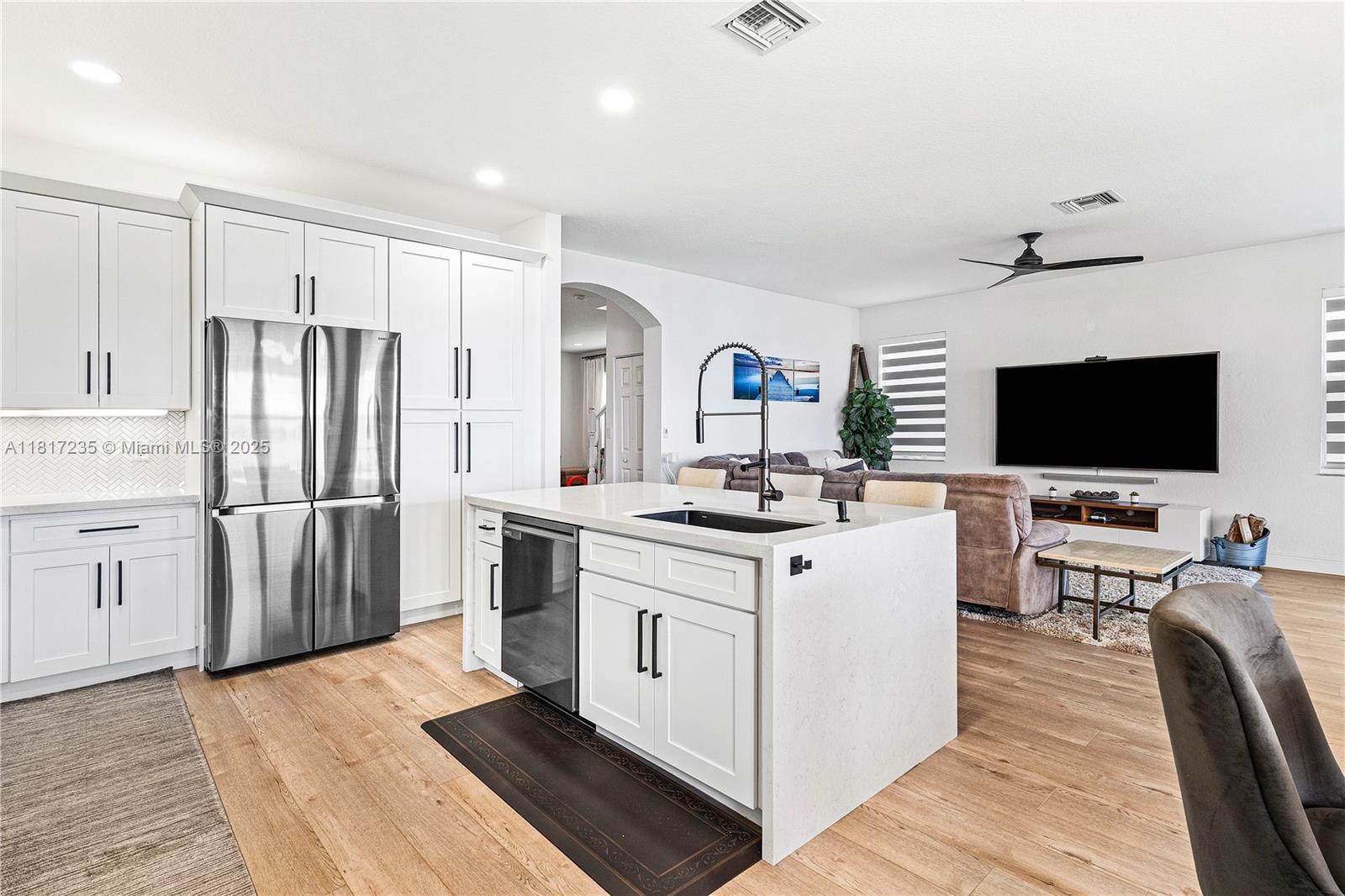 4356 Southwest 179th Way Miramar, FL 33029 - Photo 21 of 65 a kitchen with stainless steel appliances a stove top oven a refrigerator a sink and white cabinets with wooden floor