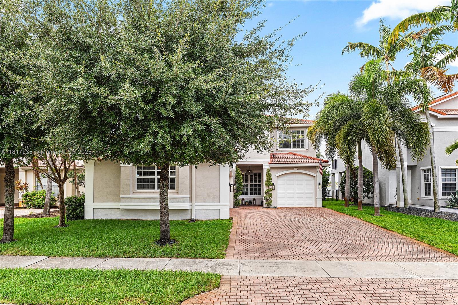 4356 Southwest 179th Way Miramar, FL 33029 - Photo 7 of 65 a front view of a house with a garden and trees