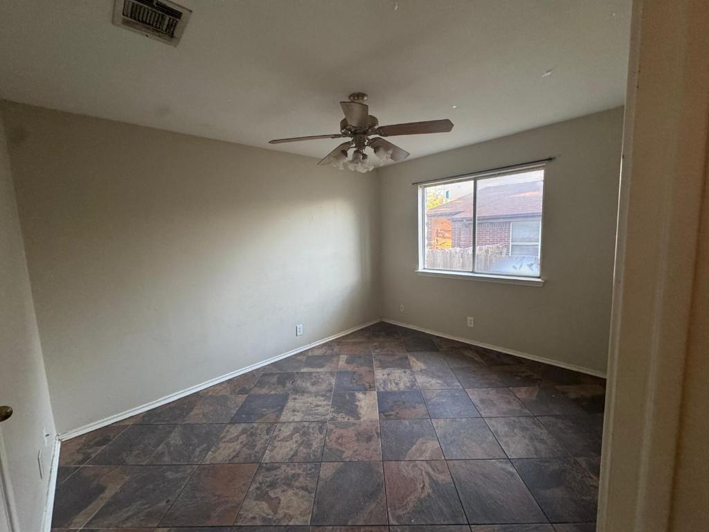 1805 Whirlwind Trail Round Rock, TX 78664 - Photo 14 of 17 Empty room with stone finish flooring and ceiling fan