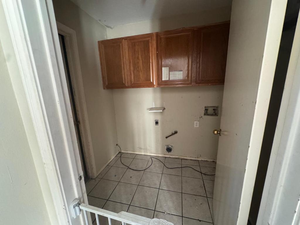 1805 Whirlwind Trail Round Rock, TX 78664 - Photo 16 of 17 Laundry area featuring cabinet space, hookup for a washing machine, light tile patterned floors, hookup for a gas dryer, and electric dryer hookup