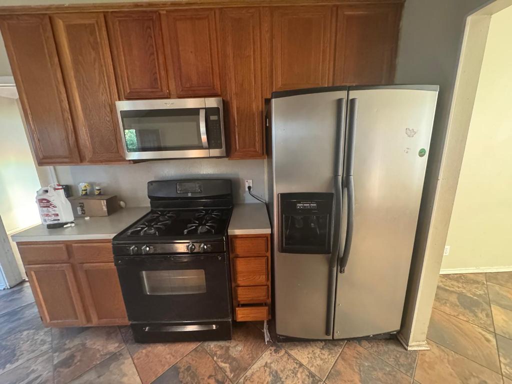 1805 Whirlwind Trail Round Rock, TX 78664 - Photo 7 of 17 Kitchen with stainless steel appliances, light countertops, and brown cabinets