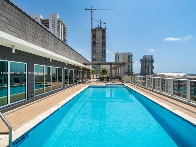 a view of balcony with a large pool and wooden floor