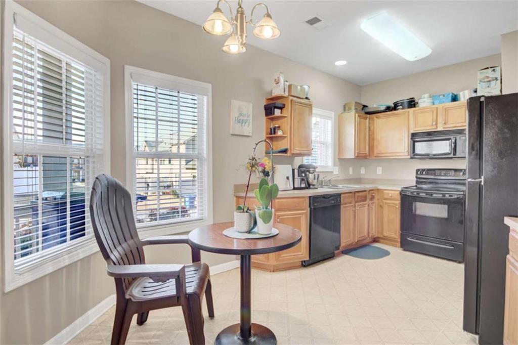 2555 Flat Shoals Road South Fulton, GA 30349 - Photo 11 of 20 a kitchen with a refrigerator a stove a sink dishwasher with a dining table and chairs