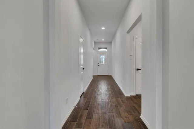 a view of a hallway with wooden floor