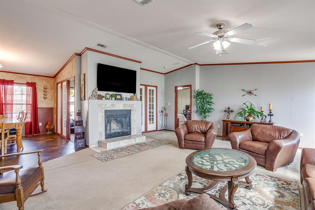 321 Young Road Millsap, TX 76066 - Photo 7 of 28 a living room with furniture a flat screen tv and a fireplace
