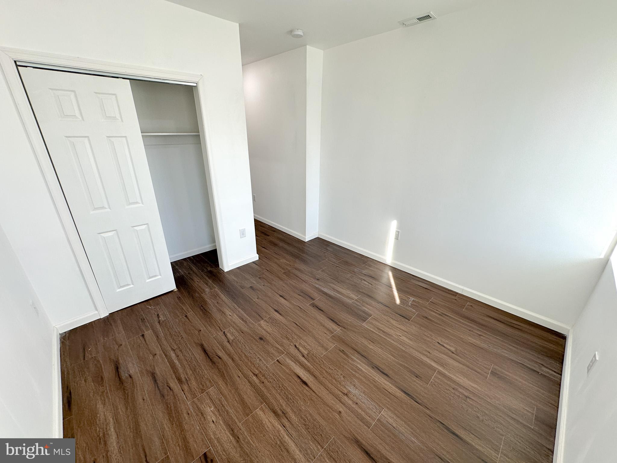 2317 North 15th Street, Unit 3 Philadelphia, PA 19132 - Photo 11 of 12 an empty room with wooden floor and closet