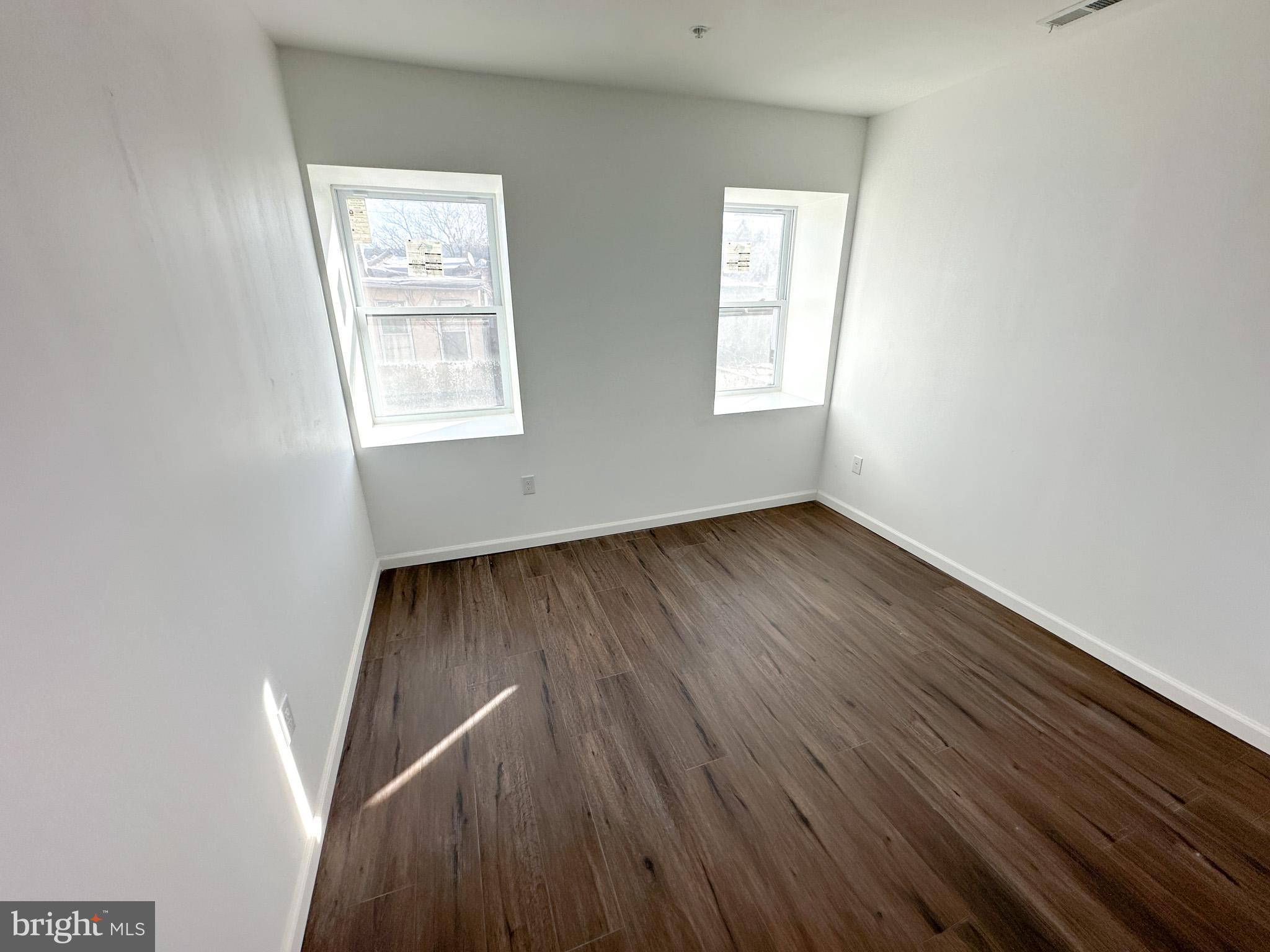 2317 North 15th Street, Unit 3 Philadelphia, PA 19132 - Photo 10 of 12 an empty room with wooden floor and windows