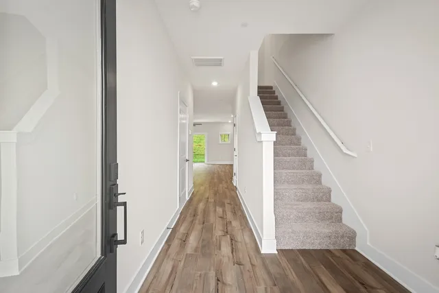 a view of a hallway with wooden floor and staircase