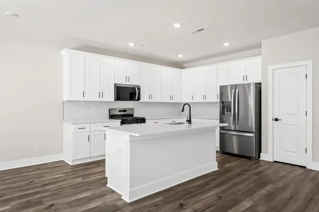 a kitchen with stainless steel appliances a refrigerator stove microwave and sink