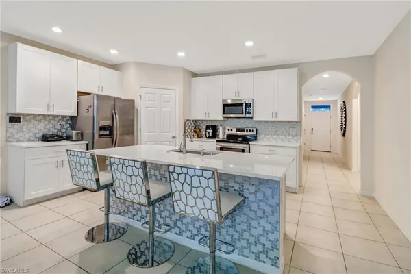 a kitchen with stainless steel appliances granite countertop a stove a sink a microwave a refrigerator and cabinets