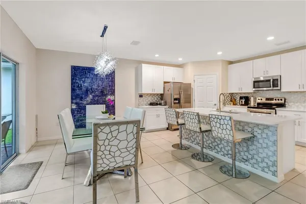a kitchen with kitchen island granite countertop a stove a sink a oven a dining table and chairs