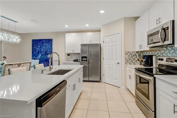 a kitchen with stainless steel appliances a sink stove refrigerator and cabinets
