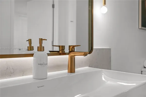a close view of a faucet a sink and a mirror
