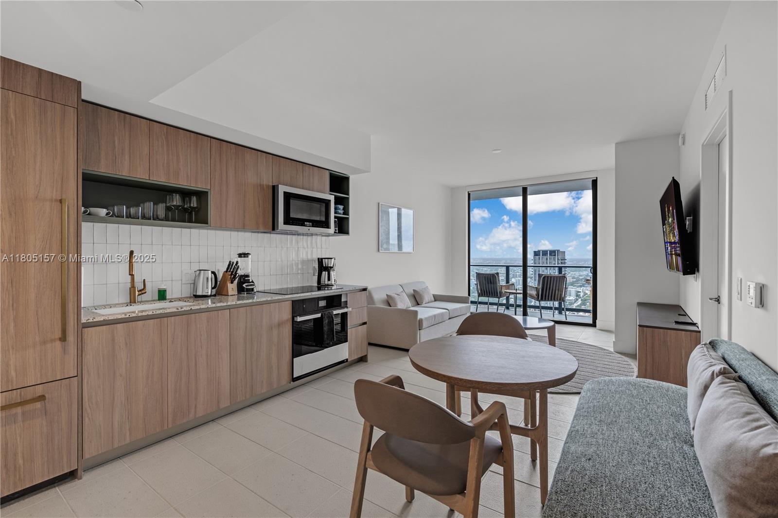 601 Northeast 1st, Unit 4204 Miami, FL 33132 - Photo 3 of 25 a kitchen with stainless steel appliances granite countertop a stove a sink a microwave a dining table and chairs