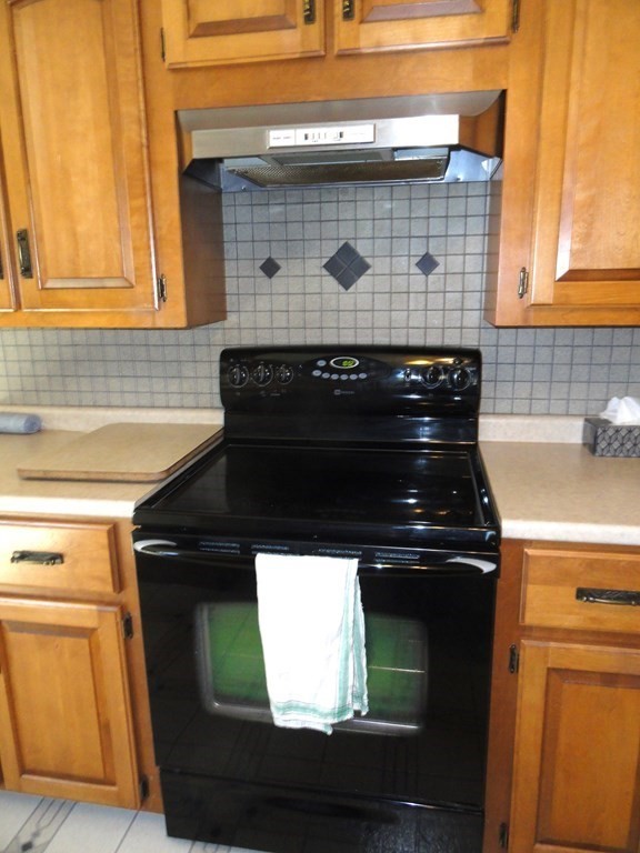 88 Charlton Road Dudley, MA 01571 - Photo 14 of 40 a close view of a stove and has a microwave oven on the wall