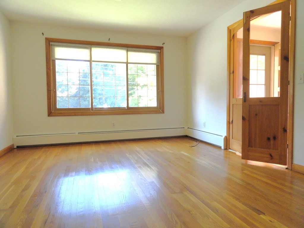 88 Charlton Road Dudley, MA 01571 - Photo 6 of 40 an empty room with wooden floor and windows
