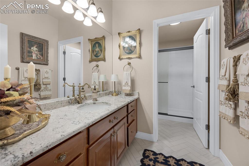 13320 Clinet Drive Colorado Springs, CO 80921 - Photo 36 of 50 a bathroom with a granite countertop sink a mirror and a shower