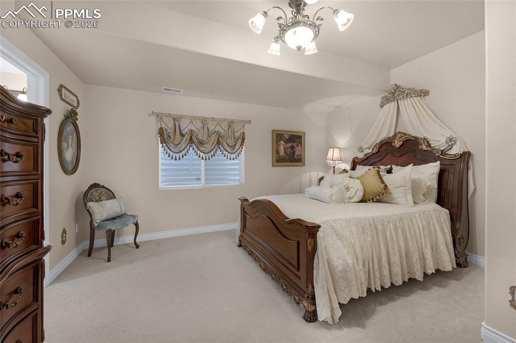 13320 Clinet Drive Colorado Springs, CO 80921 - Photo 39 of 50 a bedroom with bed and a chandelier