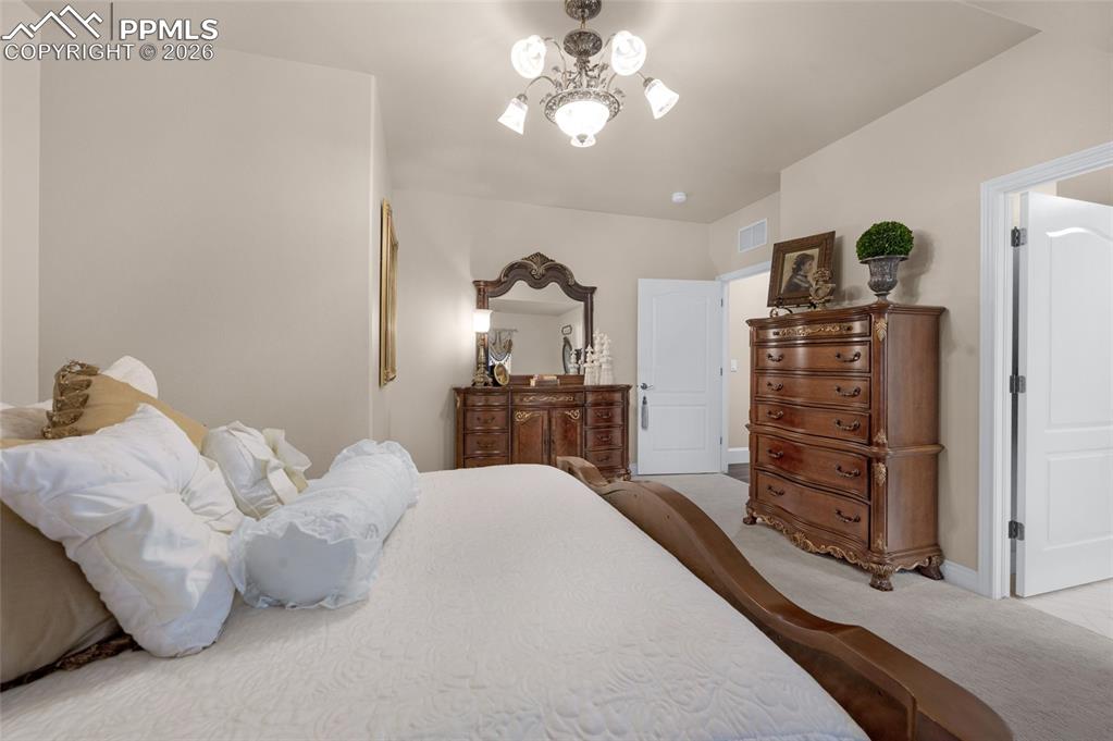13320 Clinet Drive Colorado Springs, CO 80921 - Photo 40 of 50 a bedroom with a bed and a chandelier