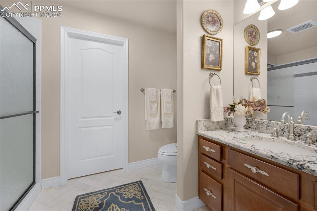 13320 Clinet Drive Colorado Springs, CO 80921 - Photo 41 of 50 a spacious bathroom with a granite countertop sink a toilet and a mirror
