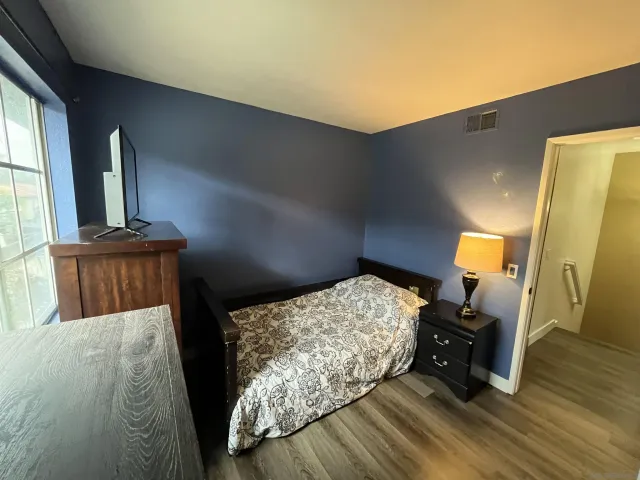 a bed sitting in a bedroom next to a window