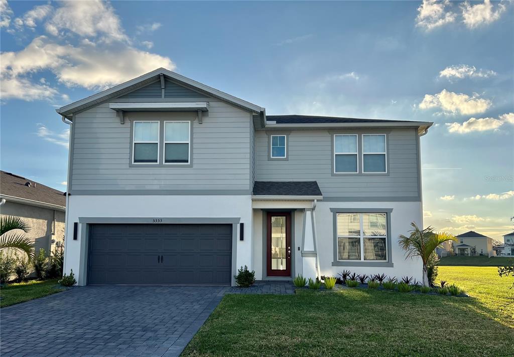 a front view of a house with a garden and plants