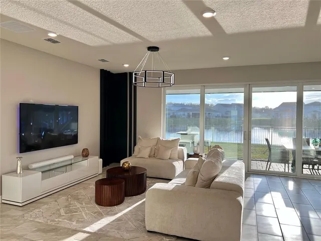 a kitchen with stainless steel appliances granite countertop a sink a stove a refrigerator and chairs