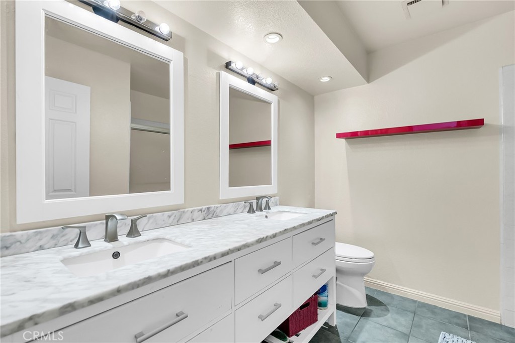 10651 Orchard View Lane Riverside, CA 92503 - Photo 22 of 35 a bathroom with a granite countertop double vanity sink a mirror and a bathtub