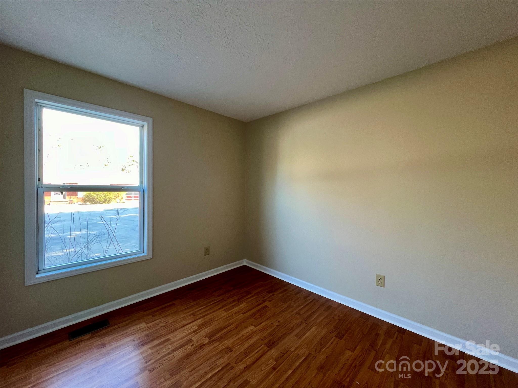 3 Wesley Branch Road Asheville, NC 28806 - Photo 10 of 19 a view of an empty room with wooden floor and a window