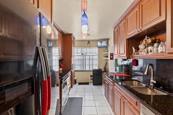 a kitchen with granite countertop a sink stove and cabinets