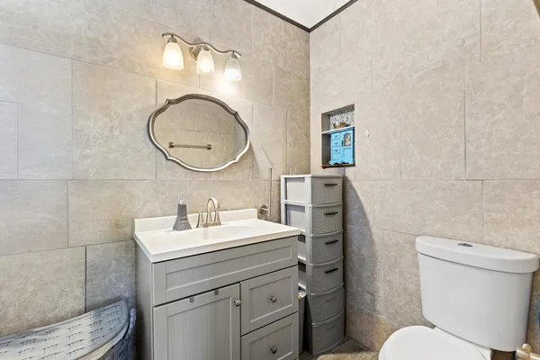 a bathroom with a toilet sink vanity and mirror