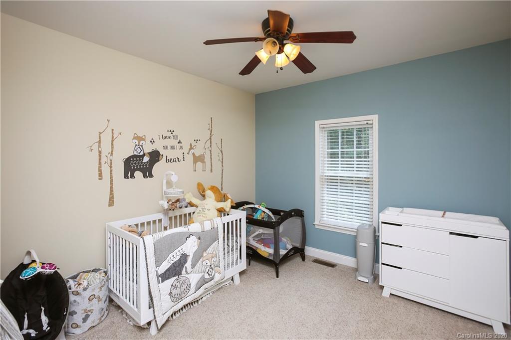 8737 Swift Road Oakboro, NC 28129 - Photo 12 of 19 a bedroom with a bed and a chandelier