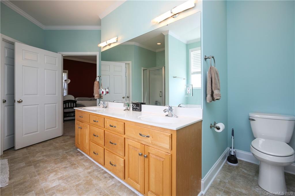 8737 Swift Road Oakboro, NC 28129 - Photo 16 of 19 a spacious bathroom with a double vanity sink toilet and mirror
