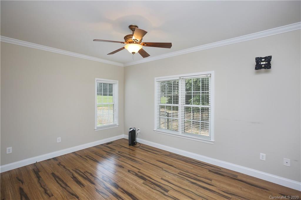 8737 Swift Road Oakboro, NC 28129 - Photo 8 of 19 a view of empty room with wooden floor and fan