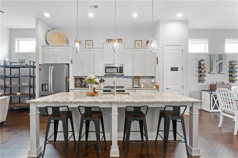141 Fieldbrook Crossing Canton, GA 30115 - Photo 14 of 45 a kitchen with stainless steel appliances granite countertop a table chairs sink and cabinets
