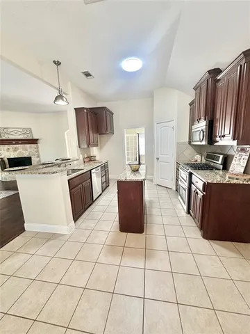 a kitchen with stainless steel appliances a stove a sink a microwave and a refrigerator