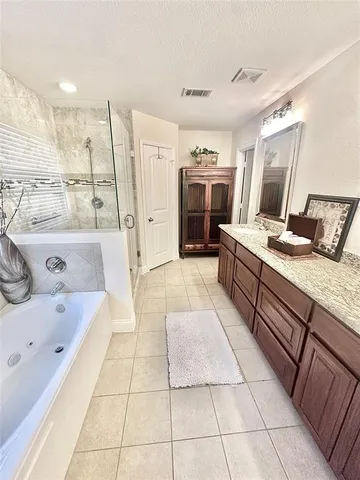 a large bathroom with a tub sink and mirror