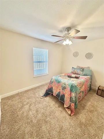 a bedroom with a bed and a ceiling fan