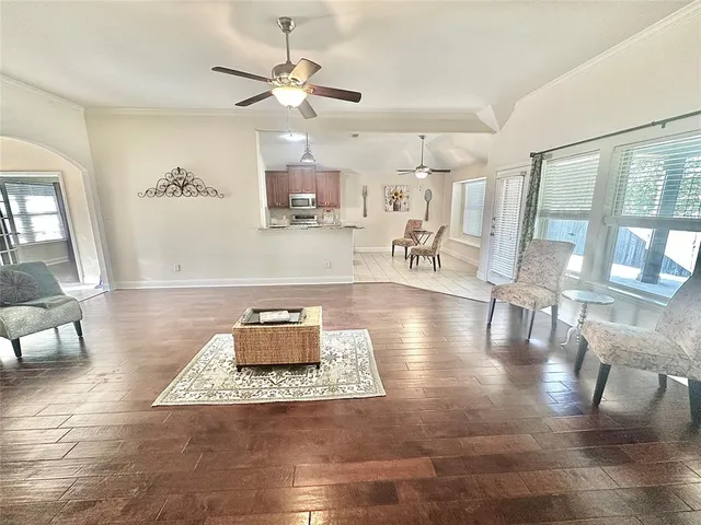 a living room with furniture and a wooden floor