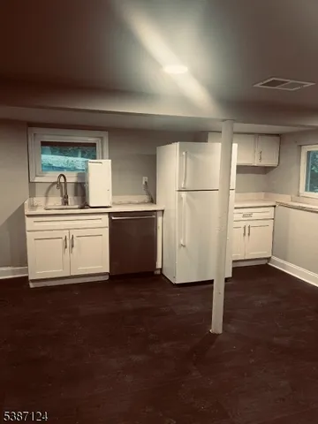 a kitchen with a refrigerator sink and cabinets