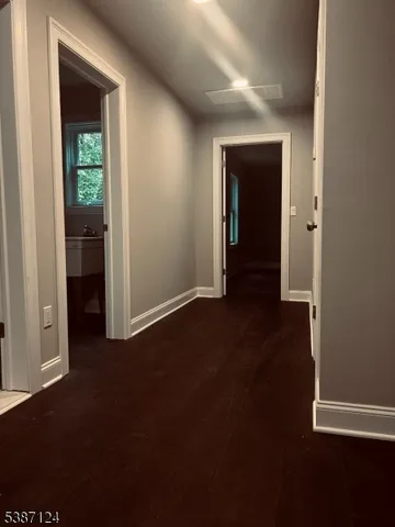 a view of a hallway with wooden floor and closet